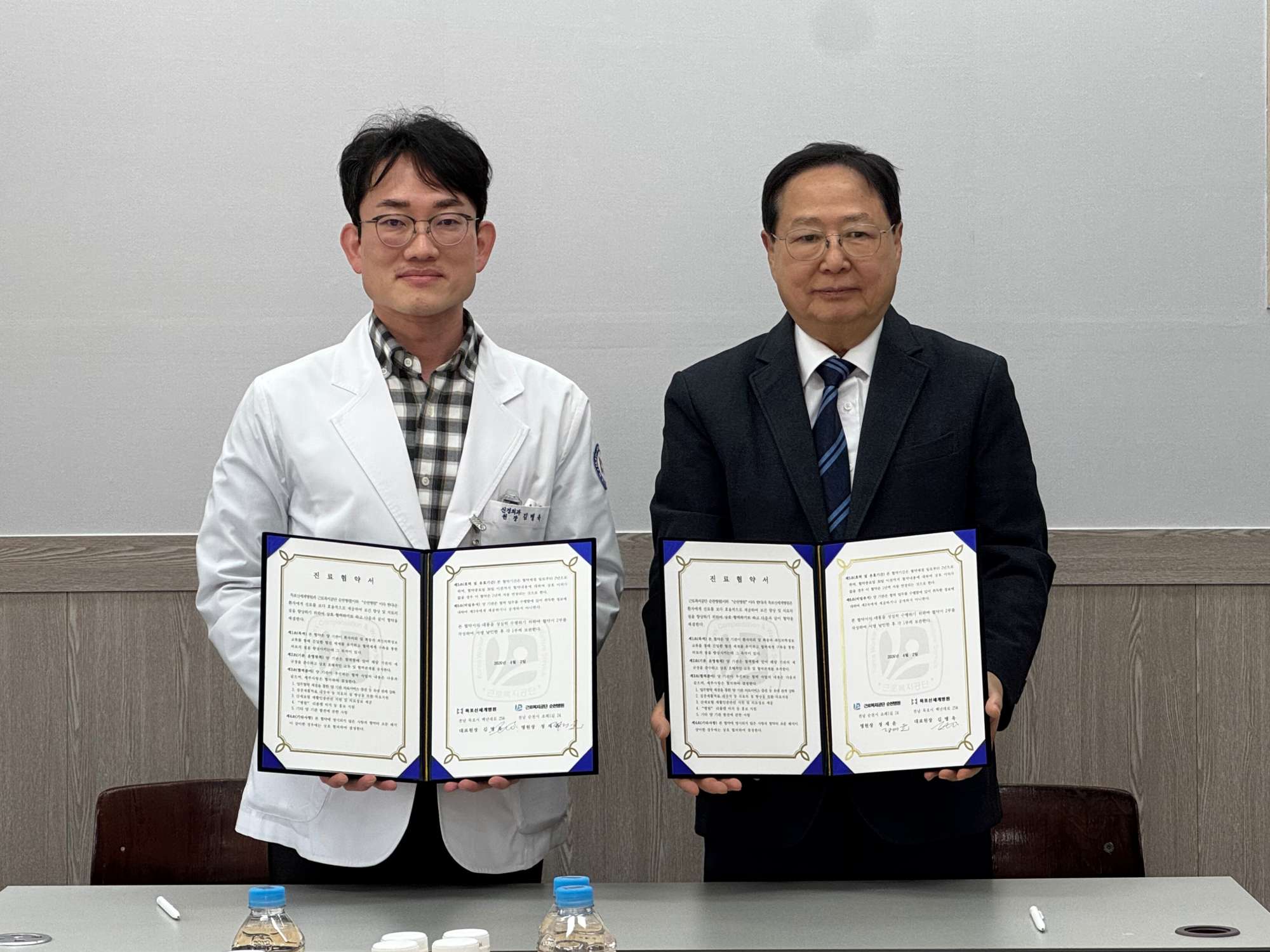 목포신세계병원 김병욱 대표원장과 근로복지공단 순천병원 정재윤 병원장이 서명된 진료협약서를 들고 서 있다.